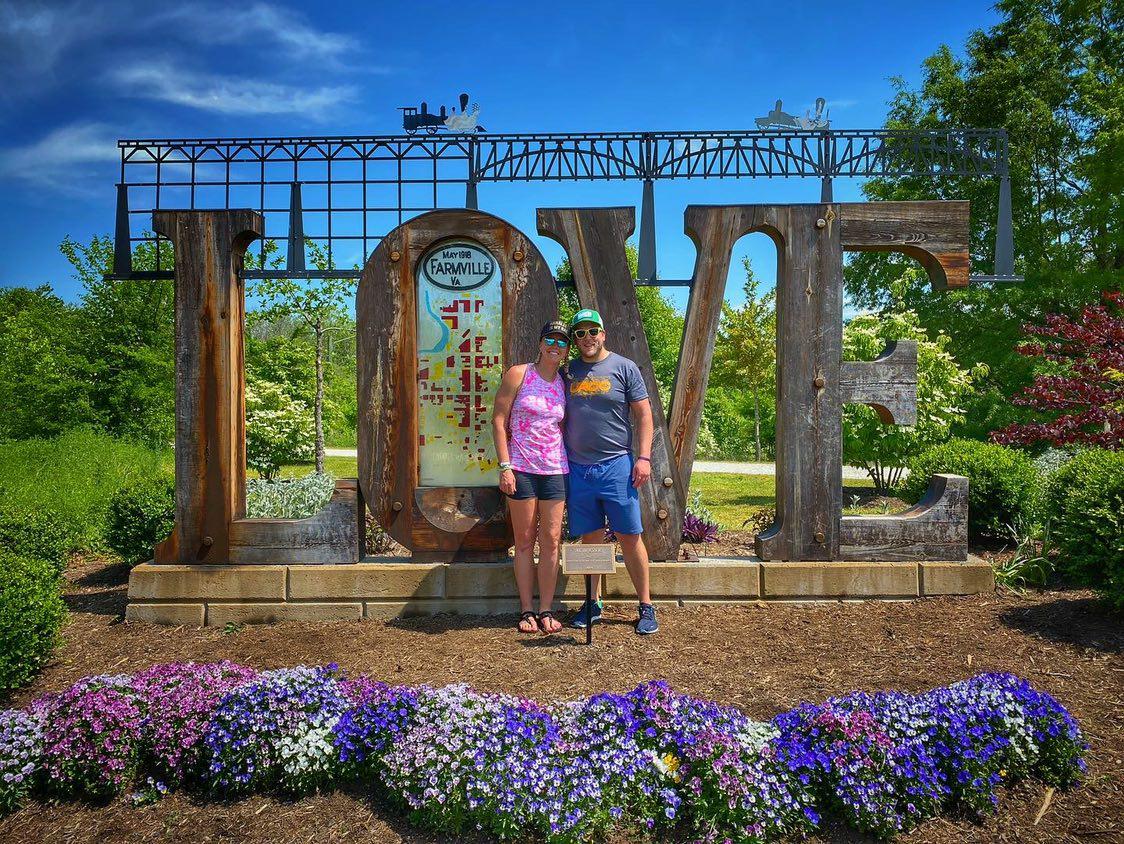 couple in front of love sign